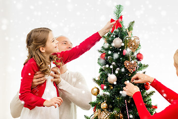 Image showing smiling family decorating christmas tree at home