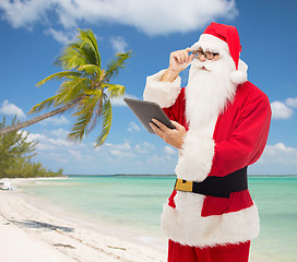 Image showing man in costume of santa claus with tablet pc