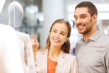 Image showing happy couple pointing finger to shop window