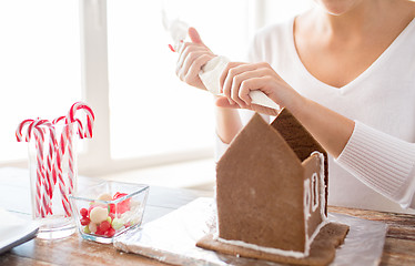 Image showing close up of woman making gingerbread houses