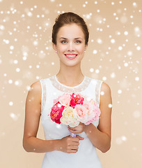 Image showing smiling woman in white dress with flowers