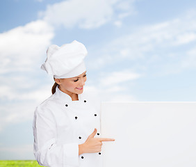 Image showing smiling female chef with white blank board