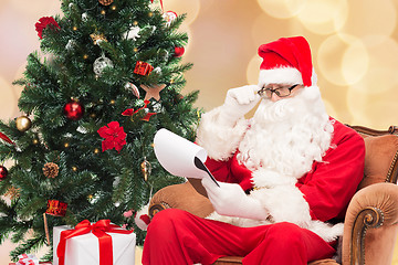 Image showing man in costume of santa claus with notepad