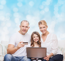 Image showing happy family with laptop computer and credit card