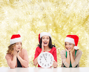 Image showing smiling women in santa helper hat with clock