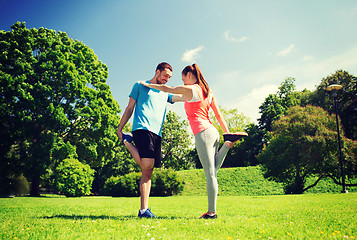 Image showing smiling couple stretching outdoors