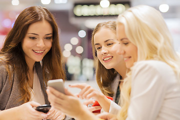 Image showing happy women with smartphones and tablet pc in mall