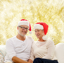 Image showing happy senior couple in santa helper hats