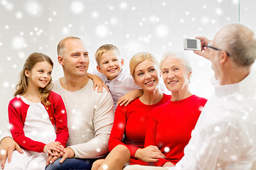 Image showing smiling family with camera at home