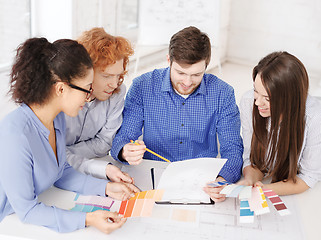 Image showing team with color samples and blueprint at office