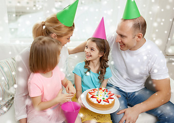 Image showing happy family with two kids in party hats at home