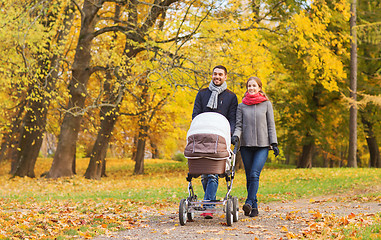 Image showing smiling couple with baby pram in autumn park