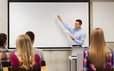 Image showing group of students and smiling teacher with notepad