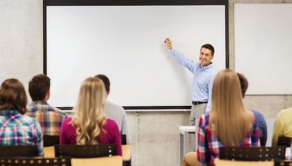 Image showing group of students and smiling teacher in classroom