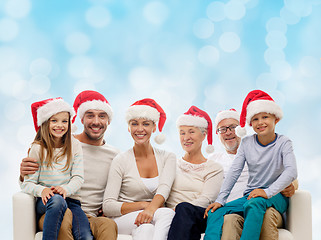 Image showing happy family in santa helper hats sitting on couch