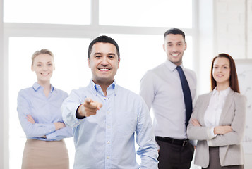 Image showing businessman in office pointing finger at you