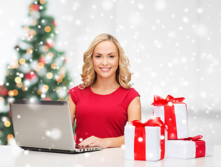 Image showing woman with gift boxes and laptop computer