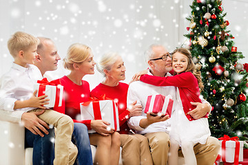 Image showing smiling family with gifts hugging at home