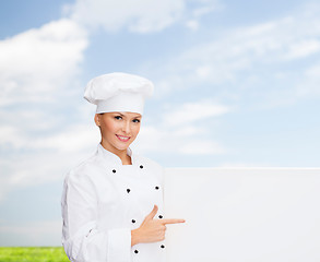 Image showing smiling female chef with white blank board