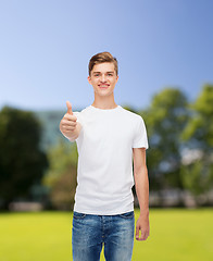 Image showing smiling man in white t-shirt showing thumbs up