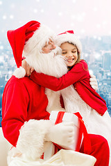 Image showing smiling little girl with santa claus and gifts