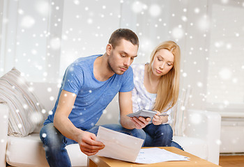 Image showing busy couple with papers and calculator at home