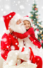 Image showing smiling girl with santa claus and gift at home