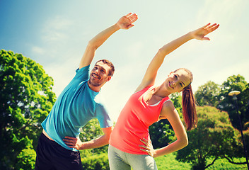 Image showing smiling couple stretching outdoors