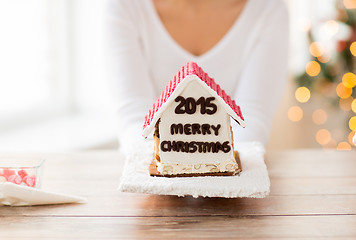 Image showing close up of woman showing gingerbread house