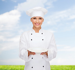 Image showing smiling female chef with empty plate