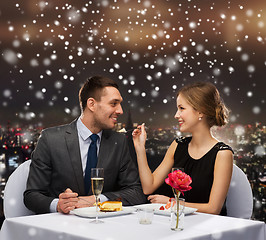 Image showing smiling couple eating dessert at restaurant