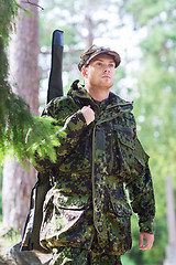 Image showing young soldier or hunter with gun in forest