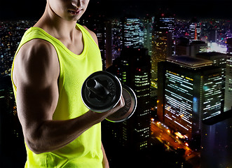 Image showing close up of young man with dumbbell flexing biceps