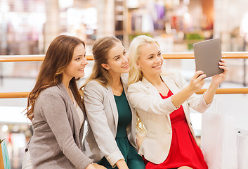 Image showing happy young women with tablet pc and shopping bags