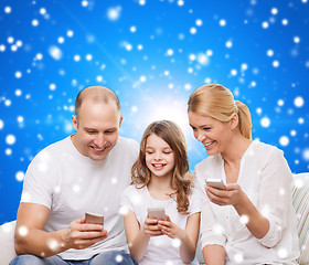 Image showing happy family with smartphones