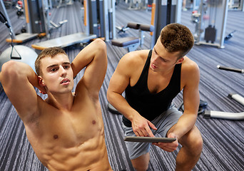 Image showing men flexing abdominal muscles in gym