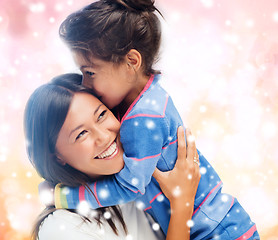 Image showing smiling little girl and mother hugging indoors