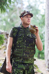 Image showing young soldier with gun and flask in forest