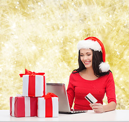 Image showing smiling woman with gifts, laptop and credit card