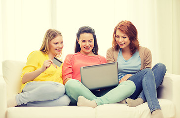 Image showing smiling teenage girls with laptop and credit card