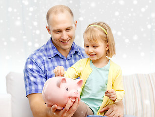 Image showing happy father and daughter with big piggy bank