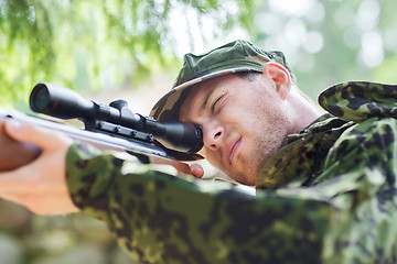 Image showing young soldier or hunter with gun in forest