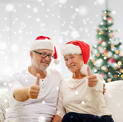 Image showing happy senior couple in santa helper hats