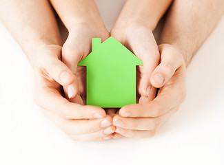 Image showing man and woman hands with green paper house