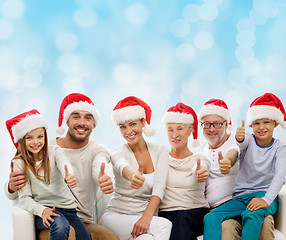 Image showing happy family in santa hats showing thumbs up