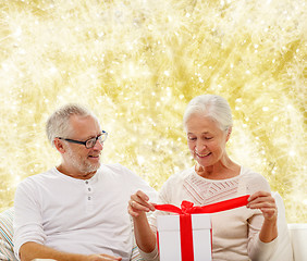 Image showing happy senior couple with gift box at home