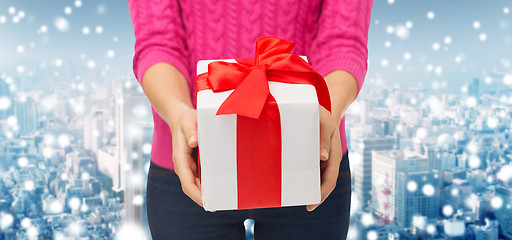 Image showing close up of woman in pink sweater holding gift box