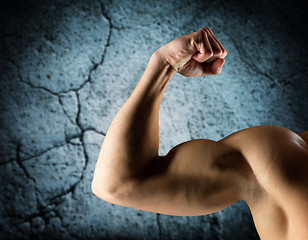 Image showing close up of young man flexing and showing biceps