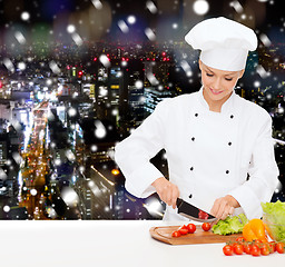 Image showing smiling female chef chopping vegetables