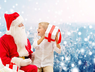 Image showing smiling little boy with santa claus and gifts